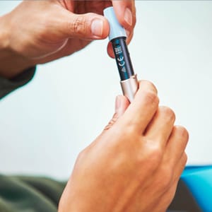 Käed hoiavad ja puhastavad IQOS 3 DUO hoidjat