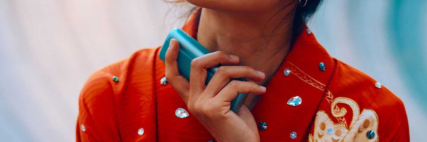 Руки держат IQOS ILUMA i PRIME над сумками.