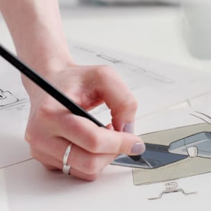 Женская рука держит карандаш и рисует устройство IQOS.