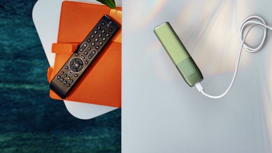 Руки вставляющие IQOS ILUMA ONE в адаптер питания.