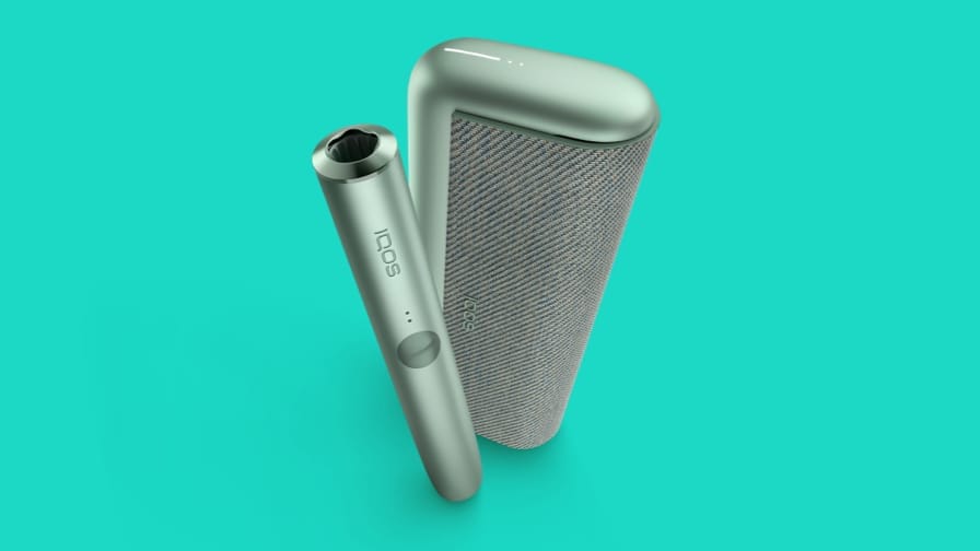 Устройство IQOS ILUMA PRIME на бирюзовом фоне.